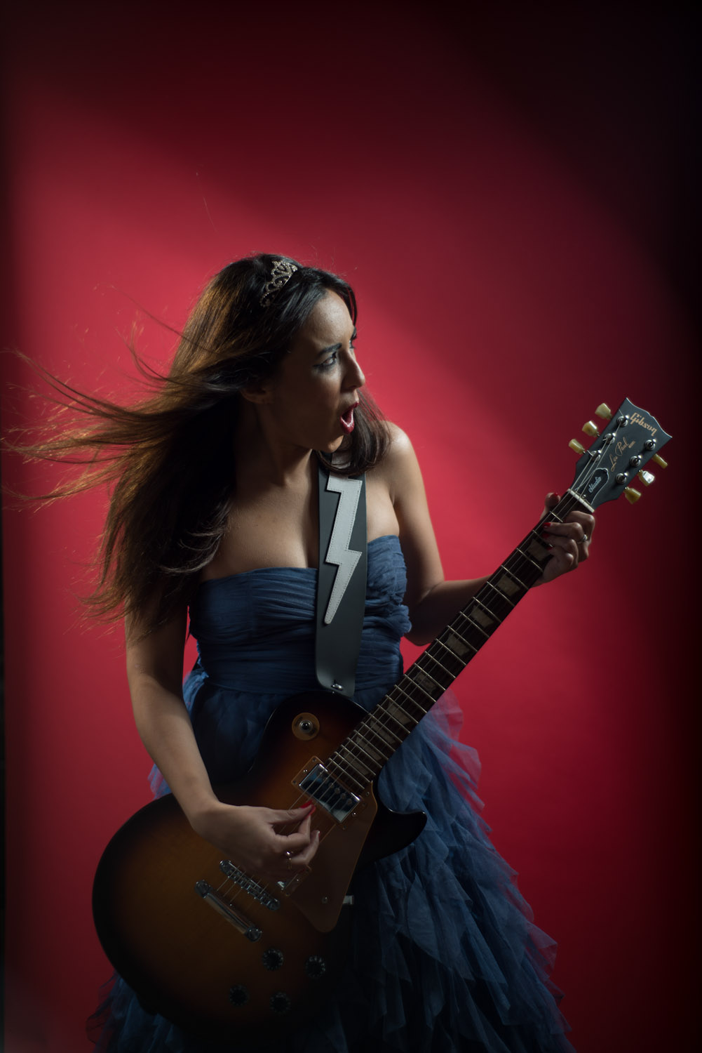 Jeune femme en robe bleue qui joue de la guitare électrique