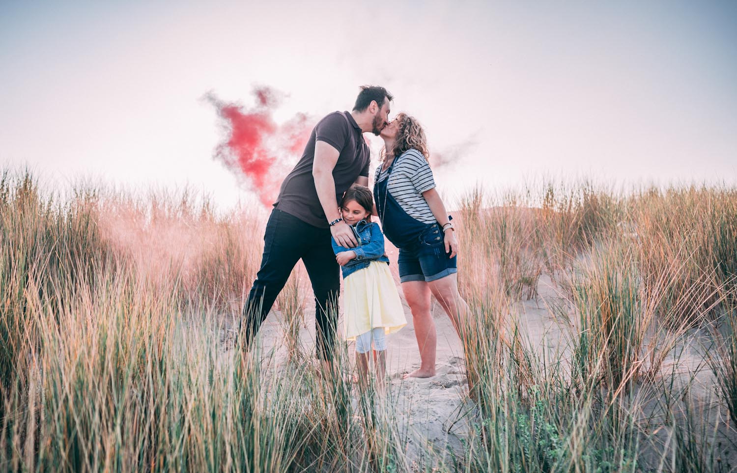 Photo de famille et grossesse à la mer et fumigène rouge