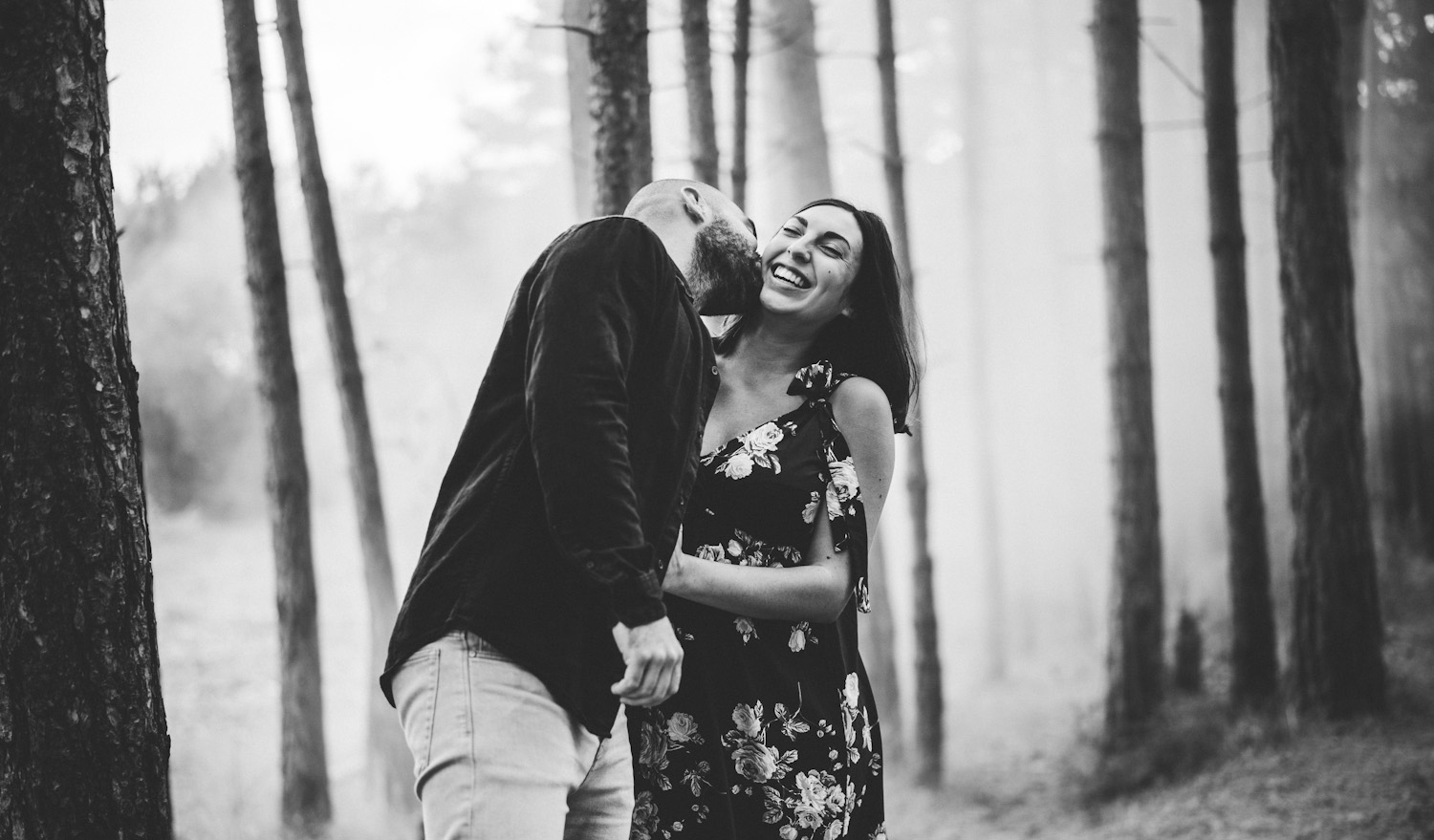 Jeune couple dans un bois en fin de journée en noir et blanc